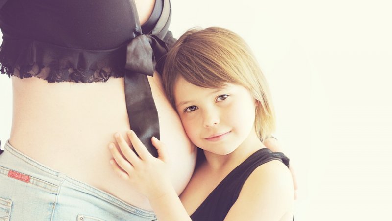Kobieta w ciąży, która ma starsze dziecko, czasem musi je podnieść, trzeba jednak wiedzieć, jak to robić (fot. pixabay)